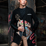 Man wearing a stylish jacket with colorful designs in a dark, textured setting