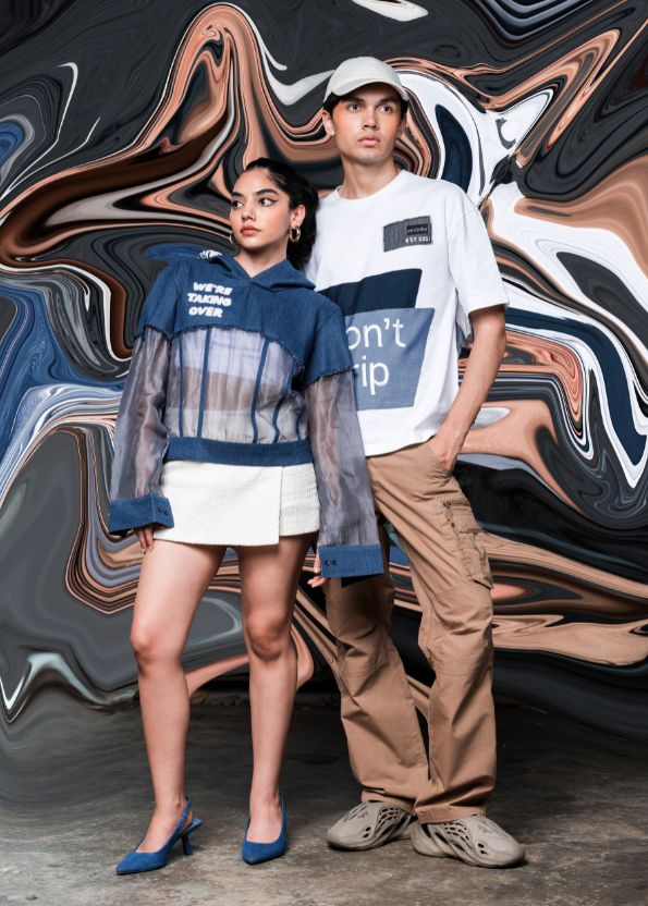 Two people standing in front of a colorful abstract background