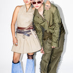 Two people wearing futuristic outfits with a plain background