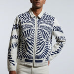 Man wearing a patterned jacket on a plain background