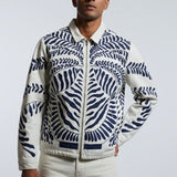 Man wearing a patterned jacket on a plain background