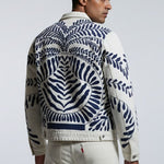 Man wearing a patterned jacket on a plain background