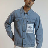 Man wearing a blue denim jacket with a visible brand label on a plain background