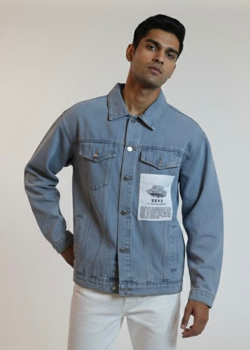 Man wearing a blue denim jacket with a visible brand label on a plain background