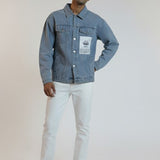 Man wearing a denim jacket and white pants on a plain background
