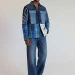 Man wearing a plaid shirt and jeans on a plain background