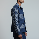 Man wearing a blue patterned jacket and pants on a gray background