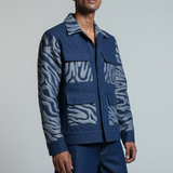 Man wearing a blue patterned jacket and pants on a gray background