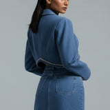 Woman wearing a blue denim outfit on a gray background