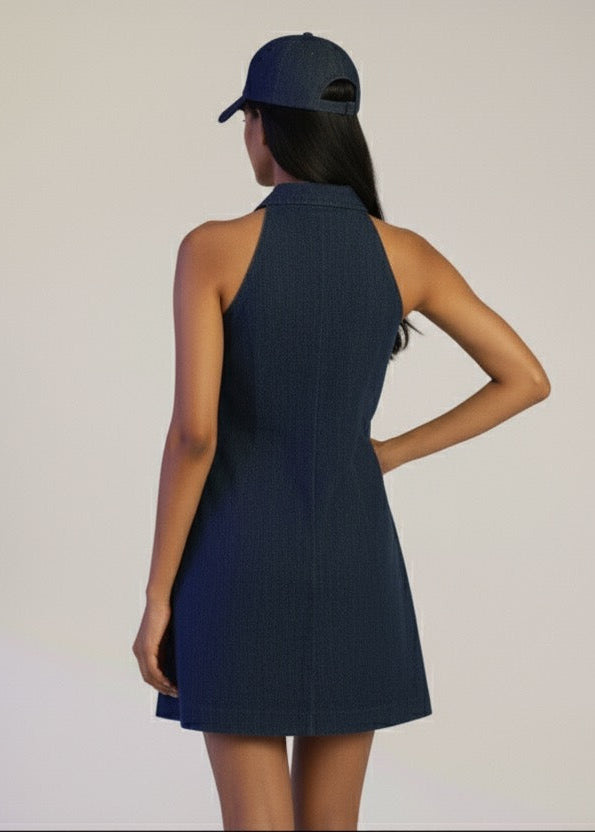 Woman wearing a navy dress and cap on a plain background