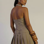 Woman wearing a beige dress with a plain background