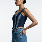 Woman wearing a blue denim top and jeans on a white background