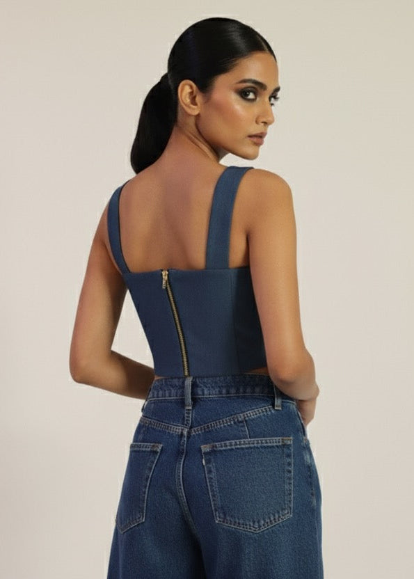 Woman wearing a blue denim jumpsuit on a beige background