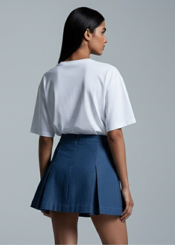 Person wearing a white top and blue skirt on a gray background