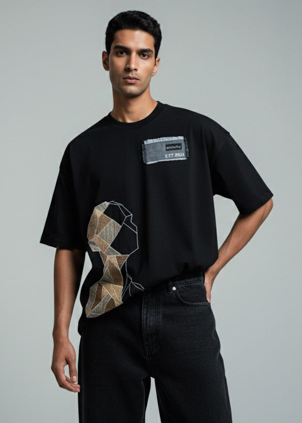 Man wearing a black t-shirt with a graphic design on a gray background