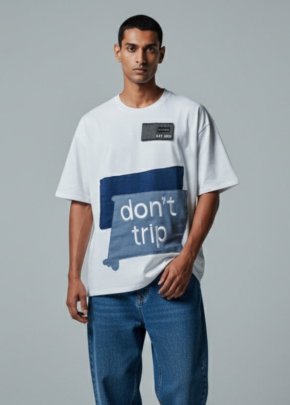 Man wearing a white t-shirt with a blue graphic and text on a gray background