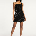 Woman wearing a black dress with white patterns on a white background