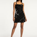 Woman wearing a black dress with white patterns on a white background