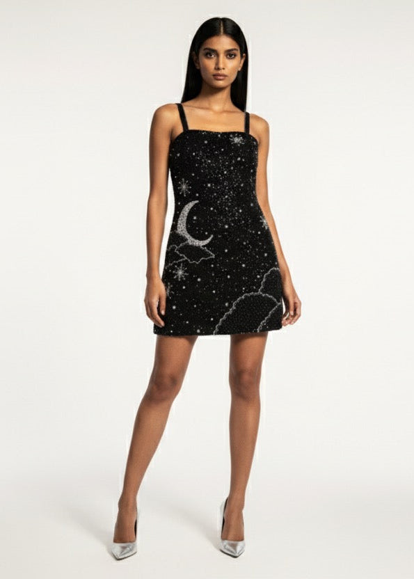 Woman wearing a black dress with white patterns on a white background