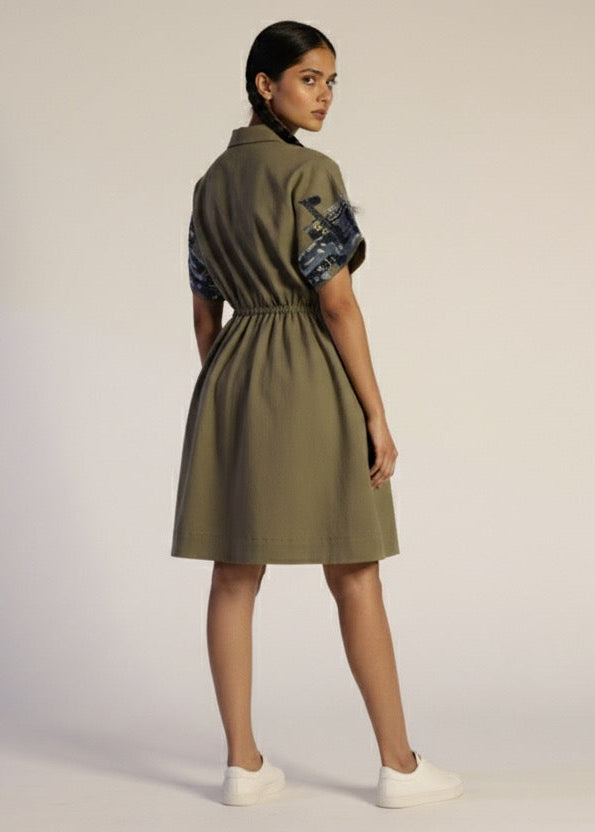 Woman wearing a green dress with blue patterns on a beige background