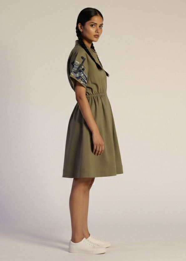Woman wearing a green dress with floral sleeves on a plain background