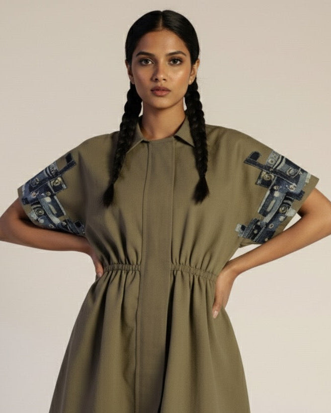 Woman wearing a green dress with patterned sleeves on a beige background