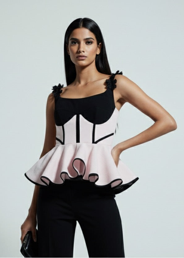Woman wearing a black and white dress with ruffled details on a gray background
