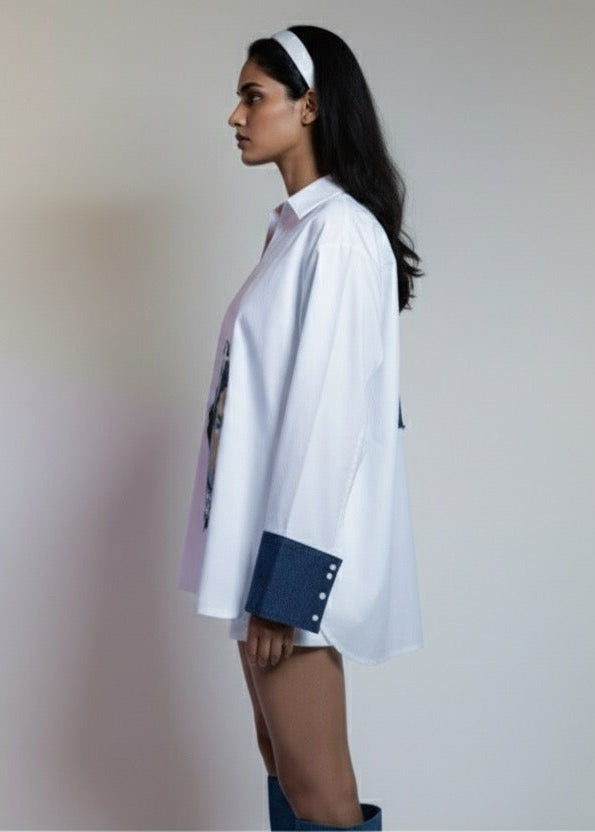 Woman wearing a white shirt with rolled-up sleeves against a plain background
