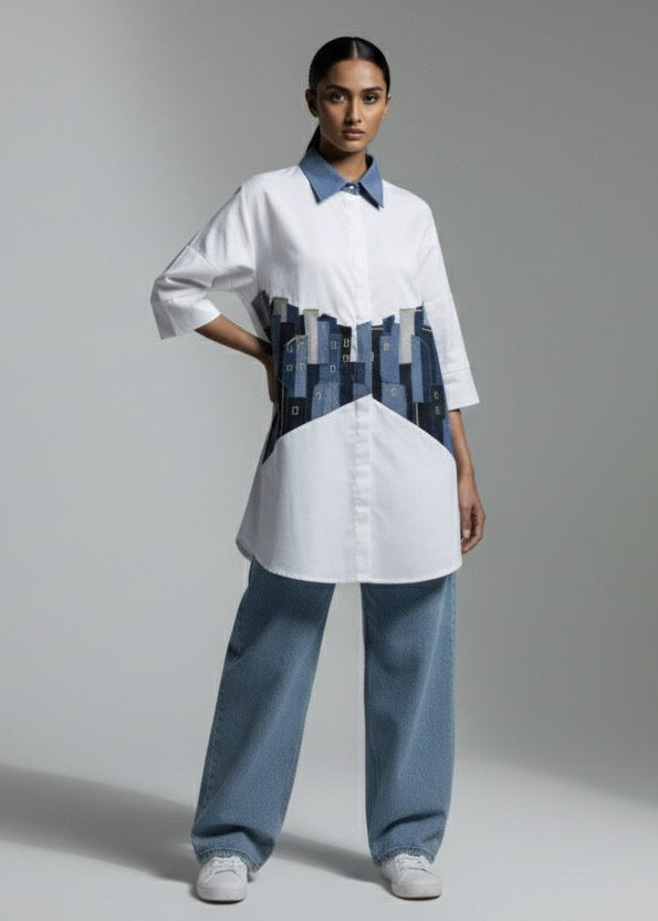 Person wearing a white shirt with a unique design on the chest against a gray background