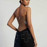 Woman wearing a black outfit with geometric patterns on a plain background