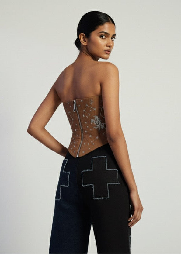 Woman wearing a black outfit with geometric patterns on a plain background