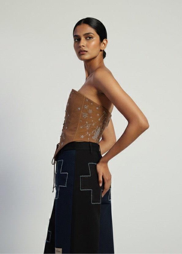 Woman wearing a black dress with geometric patterns on a plain background