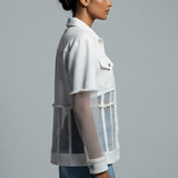 Woman wearing a white shirt with sheer panels on a gray background
