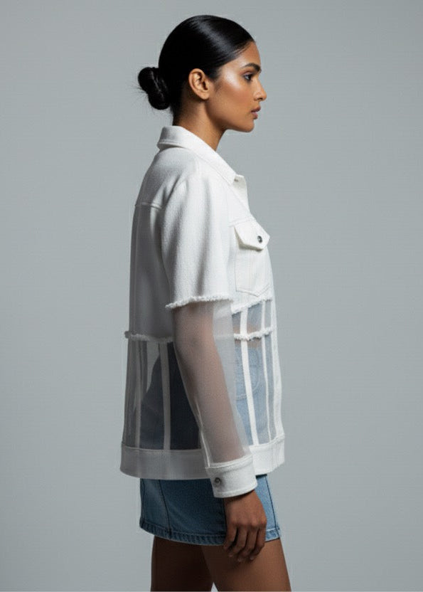 Woman wearing a white shirt with sheer panels on a gray background