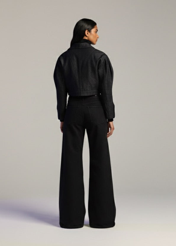 Person wearing a black outfit on a plain background
