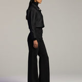Person wearing a black outfit on a plain background