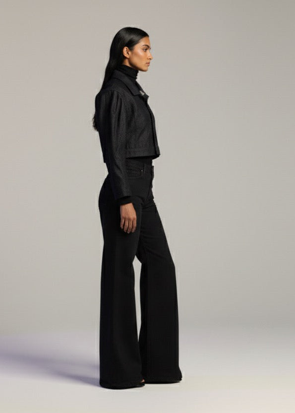 Person wearing a black outfit on a plain background