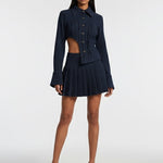 Woman wearing a navy blue outfit with a cutout design on a white background