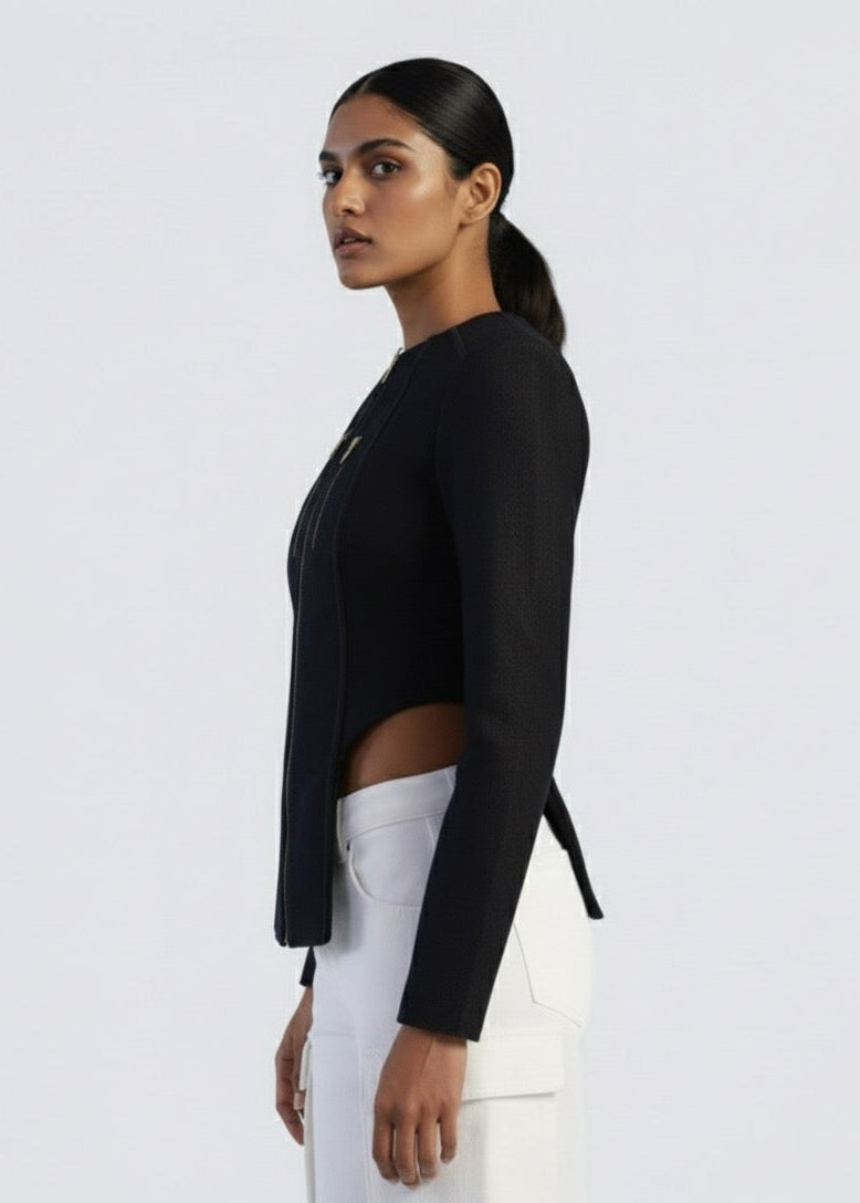 Woman wearing a black blazer and white pants on a light gray background