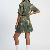 Woman wearing a green tie-dye outfit on a white background