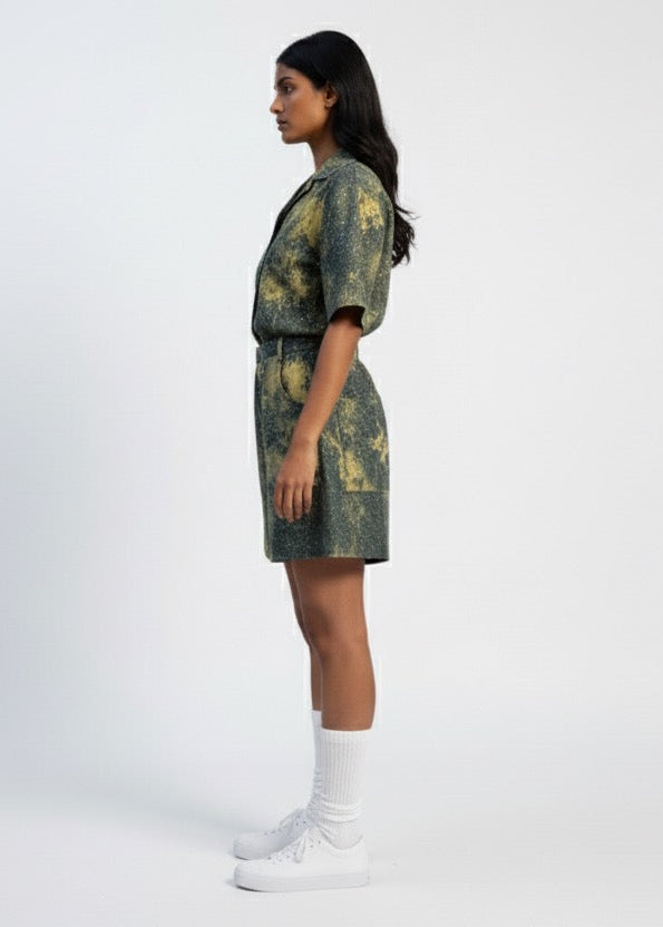 Woman wearing a green and brown patterned dress on a white background