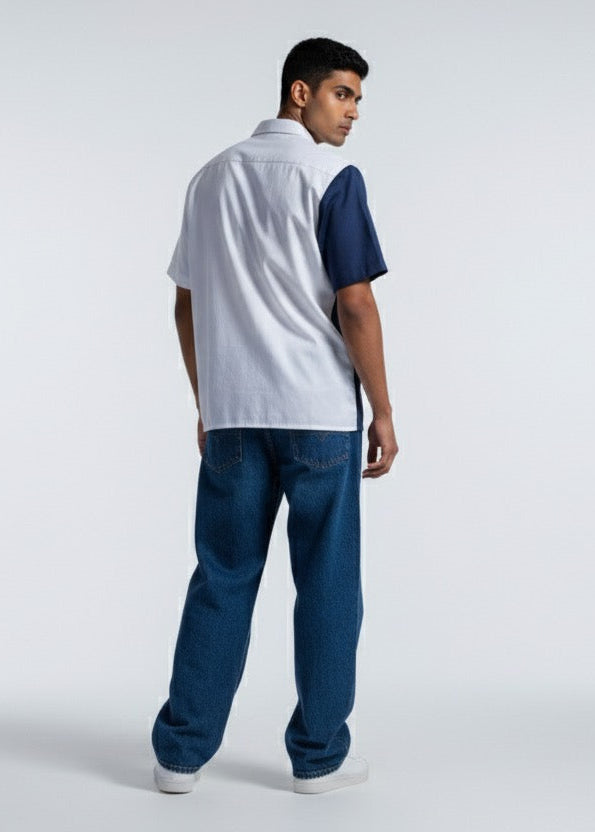 Man wearing a white and blue polo shirt with jeans on a white background