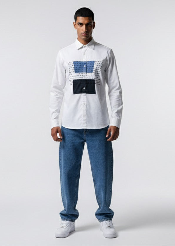 Man wearing a white shirt with a pattern and blue jeans on a white background