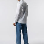 Man wearing a white shirt and blue jeans on a white background