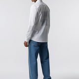 Man wearing a white shirt and blue jeans on a white background