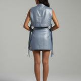 Woman wearing a silver metallic dress against a gray background