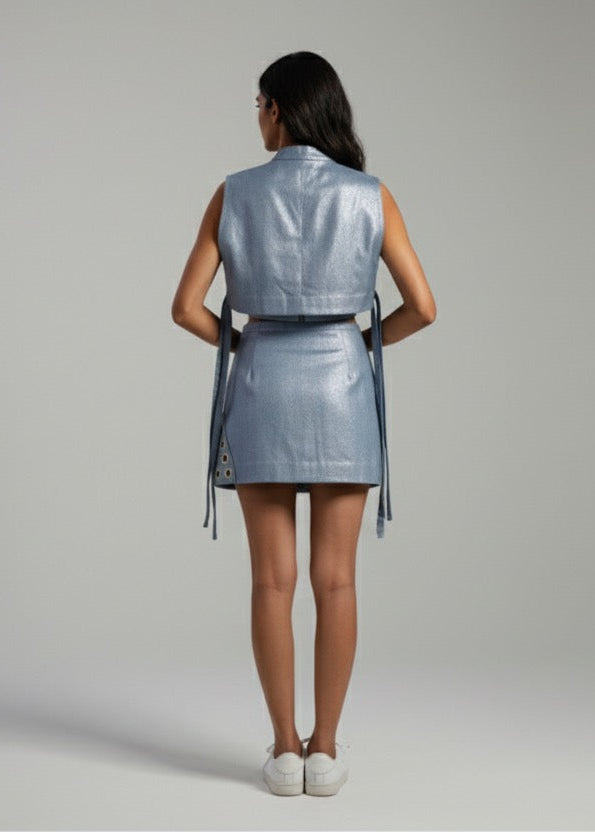 Woman wearing a silver metallic dress against a gray background