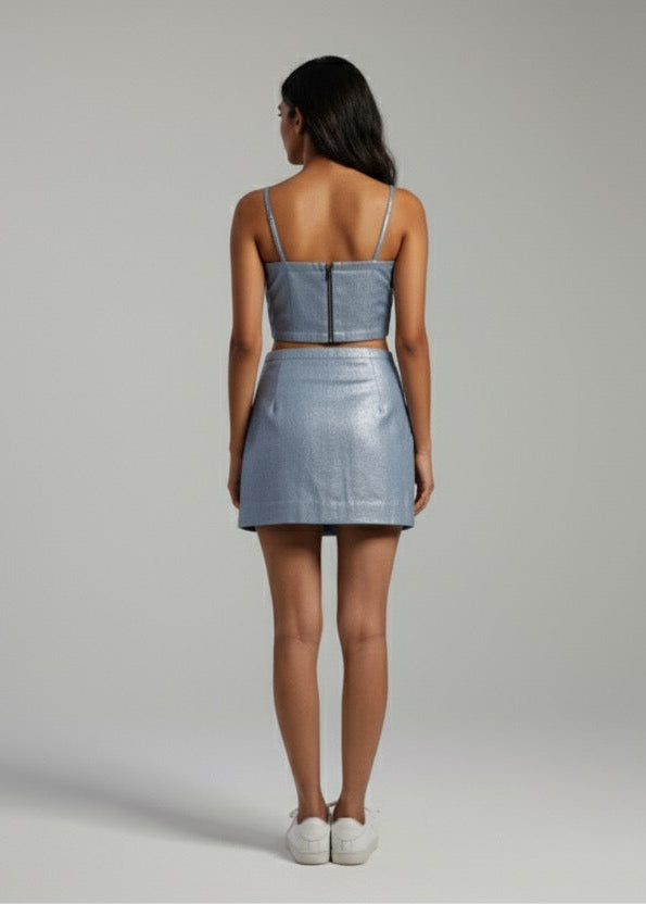 Woman wearing a light blue two-piece outfit on a plain background