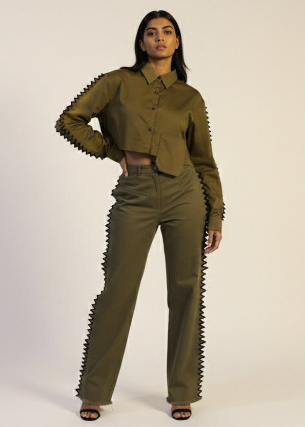 Woman wearing a green outfit with unique design elements on a white background
