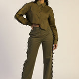 Woman wearing a green outfit with unique design elements on a white background